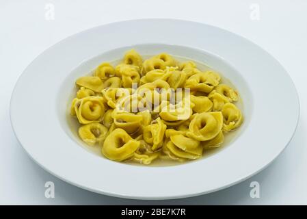 Tortellini in brodo in piatto bianco, pasta italiana emilia-romagna Foto Stock