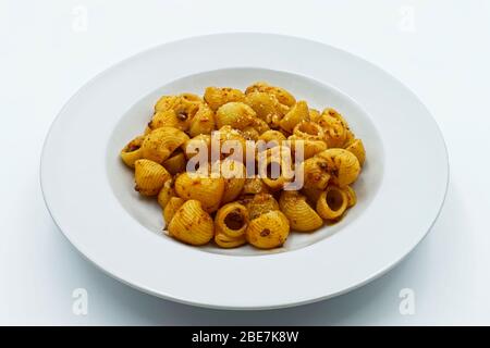 Pasta rigata, pasta con tubetto in salsa bolognese in piatto bianco. Foto Stock