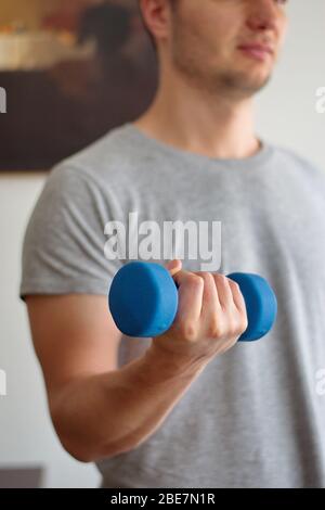 Ritratto di giovane che solleva manubri a casa Foto Stock