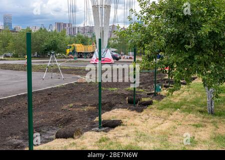 installazione di recinzioni nei parchi. ricostruzione di aree. Le attrezzature per la costruzione sono in riparazione su strada Foto Stock