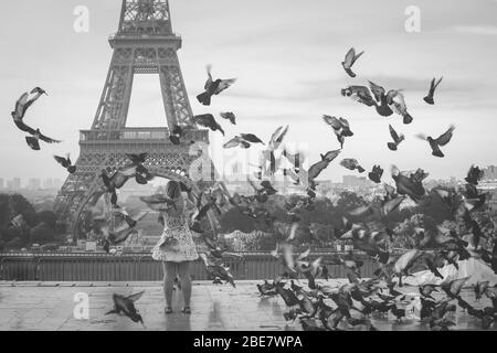 focalizzazione sul turista che prende le foto sulla torre eiffel con i piccioni che volano intorno Foto Stock