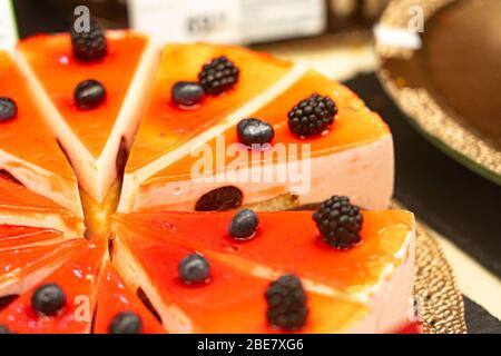 Torte e pasticcini in una vetrina. Pasticceria con varietà di ciambelle, crème brulee, torte con frutta e frutti di bosco Foto Stock