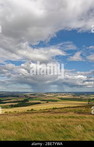 La vista verso la costa orientale della Scozia dalla cima del Forte Bianco dell'Età del ferro di Caterthun, con nuvole a pioggia in lontananza. Foto Stock