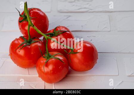 pomodori rossi maturi su un tavolo bianco Foto Stock