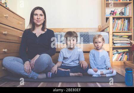 Bambini che fanno yoga online in camera da letto Foto Stock