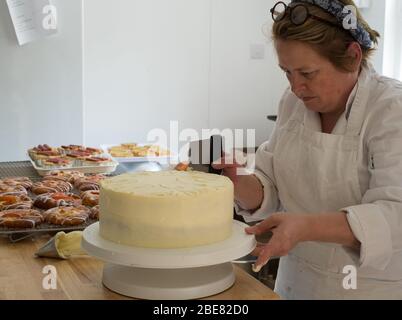 Patisier scozzese Louise Paterson glassa una torta di Hummingbird Foto Stock