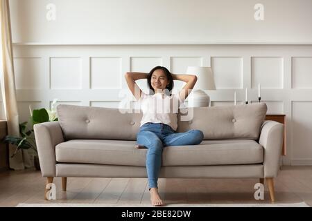 Donna asiatica che riposa sul divano godersi l'aria fresca a casa Foto Stock