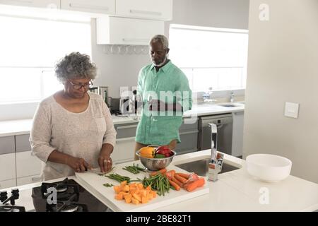 Una coppia afro-americana che trascorre il tempo insieme a casa e a cucinare Foto Stock