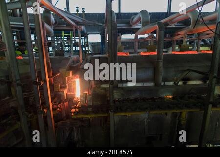 Vetreria. Industria del vetro. Sbozzati che bruciano di bottiglie di vetro in una stufa industriale. Le bottiglie calde sbozzano in fiamma. Tipico lavoro bohémien. Repubblica ceca, Foto Stock