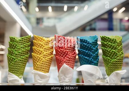 Immagine di sfondo dei coni colorati di gelato al banco del dessert nel centro commerciale, spazio per le copie Foto Stock