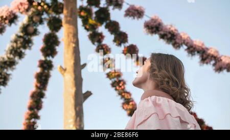 Ragazza sullo sfondo di margherite appese di fiori freschi in un parco cittadino. Foto Stock