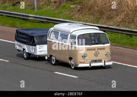 1970 anni '70 beige Classic VW Volkswagen pop top, carrello con finestra a bovindo, caravan per traino campervan anni '70; traffico veicolare nel Regno Unito, trasporto storico, veicoli in movimento, veicolo vecchio, Strade, motori amati, auto d'epoca sulla M6 autostrada Foto Stock