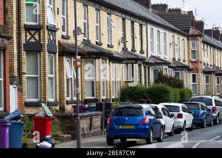 Liverpool City Council, bidoni di carenatura fuori, traboccante, in attesa di raccolta su una strada residenziale suburbana Liverpool, Merseyside, Inghilterra. Foto Stock