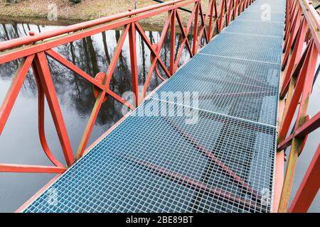 Moderno ponte in metallo con corrimano rossi, vista prospettica Foto Stock