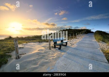 sentiero su pista panchina al sorgere del sole Foto Stock