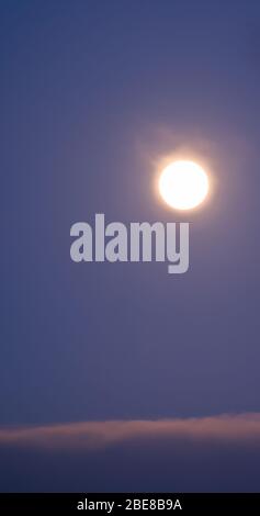 Full Moon Rising in un cielo notturno scuro Foto Stock