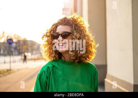 Ritratto di giovane donna con capelli ricci in città