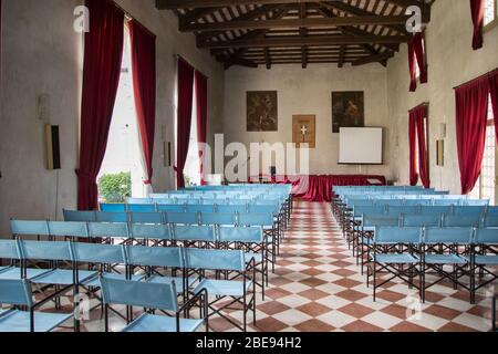 Vicenza, Italia - 13 maggio 2015: Sala conferenze con sedie blu tela e tende rosse, all'interno della villa Cordellina Lombardi. Foto Stock