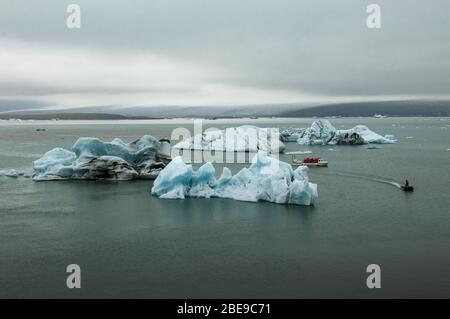 Ghiacciai e barca per escursioni nella laguna del ghiacciaio di Jokulsarlon, sulla costa meridionale dell'Islanda, in Europa Foto Stock