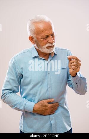 Ritratto di uomo anziano che ha dolore allo stomaco. Foto Stock