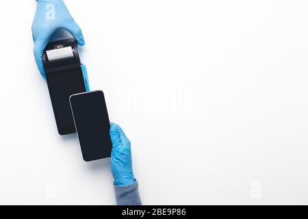 Uomo in guanti di protezione a pagamento con telefono cellulare, pay pass Foto Stock
