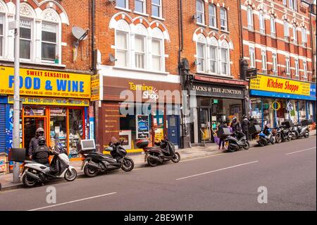 Londra, Regno Unito. 13 Aprile 2020. I conducenti di ristoranti che consegnano cibo si accodano per ritirare gli ordini a Clapham Junction Battersea il lunedì di Pasqua, in quanto le persone sono istruite a non lasciare casa. Credit: JOHNNY ARMSTEAD/Alamy Live News Foto Stock