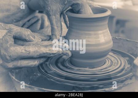 Vecchia classe photo.Master vintage sulla modellazione di argilla su una ruota di ceramica nel laboratorio di ceramica Foto Stock