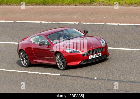 2012 rosso Aston Martin DB9 5.9 Touchtronic II 2dr (2+2) 2 porte automatico a benzina Coupé; veicoli veicolare in movimento, veicolo guida su strade britanniche, motori, motorizzazione sull'autostrada M6 Foto Stock