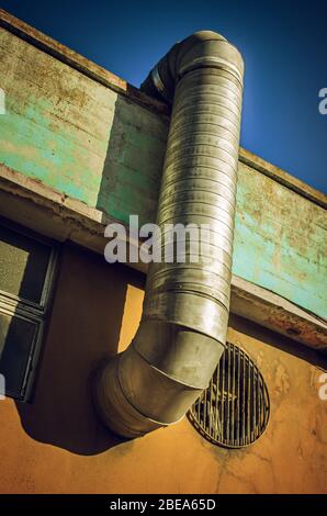 Dettaglio industriale di un tubo di ventilazione in un vecchio muro di un edificio Foto Stock