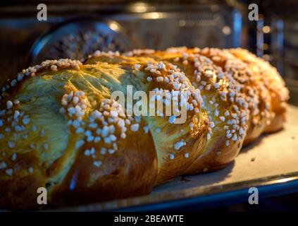 pane di lievito dolce intrecciato grande con zucchero grosso in forno Foto Stock