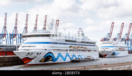 13 aprile 2020, Amburgo: Le navi da crociera AIDAaura (l) e AIDAcara sono ormeggiate al terminal dei traghetti di Steinwerder. Come misura per contenere la pandemia corona, hanno temporaneamente sospeso le loro crociere. Foto: Markus Scholz/dpa Foto Stock