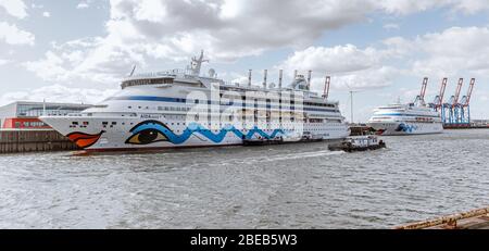 13 aprile 2020, Amburgo: Le navi da crociera AIDAaura (l) e AIDAcara sono ormeggiate al terminal dei traghetti di Steinwerder. Come misura per contenere la pandemia corona, hanno temporaneamente sospeso le loro crociere. Foto: Markus Scholz/dpa Foto Stock