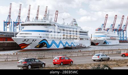 13 aprile 2020, Amburgo: Le navi da crociera AIDAaura (l) e AIDAcara sono ormeggiate al terminal dei traghetti di Steinwerder. Come misura per contenere la pandemia corona, hanno temporaneamente sospeso le loro crociere. Foto: Markus Scholz/dpa Foto Stock