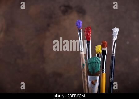 Pennelli di vernice davanti a tela sfocata Foto Stock