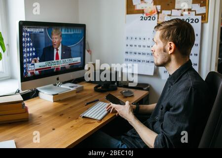 Riga, Lettonia - Aprile 04 2020: Uomo che guarda le ultime notizie. Presidente Donald Trump. Stati Uniti d'America durante la pandemia del coronavirus Foto Stock