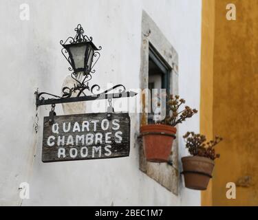 Un cartello per le camere visto su un muro di una pensione in Obidos, una città medievale che si trova su una collina sulla costa atlantica del Portogallo. Foto Stock