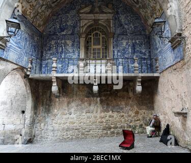 Azulejo e un busker nella porta della città di Obidos, una città medievale che si trova su una collina sulla costa atlantica del Portogallo. Foto Stock