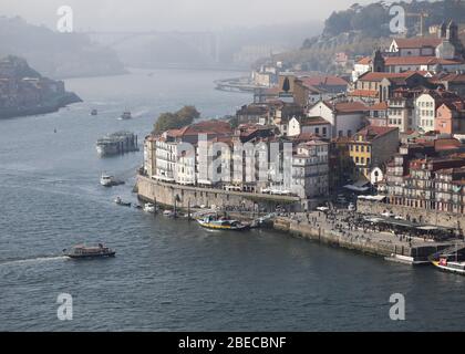Vista sul fiume Douro fino all'estuario e sulla città vecchia dal ponte Dom Luís i di Porto, la seconda città più grande del Portogallo. Foto Stock