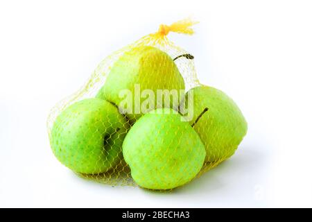 Un gruppo di mele a rete arancione appeso davanti a un muro bianco. Tendenza. Il concetto di dieta e sano mangiare verde Granny Smith e dorato Foto Stock