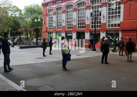 Gijon, Spagna. 11 Aprile 2020. Gijon, SPAGNA: Persone che si accodano per entrare nel mercato mentre i militari disinfettano durante il 29 ° giorno dello Stato di allarme in Spagna, a Gijon, Spagna, il 11 aprile 2020. (Foto di Alberto Brevers/Pacifc Press) Credit: Sipa USA/Alamy Live News Foto Stock