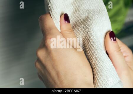 Strofinare le mani con un asciugamano. Il concetto di cura per la pulizia, igiene personale. Prevenzione delle malattie. La donna si asciuga le mani dopo averle lavate Foto Stock