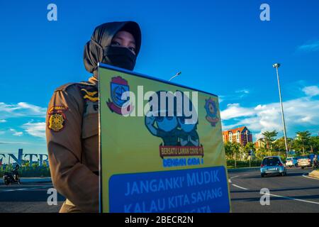 Makassar, Sulawesi del Sud, Indonesia. 13 Aprile 2020. Makassar City Servizio civile unità di polizia personale indossare maschere è scesi per le strade esortando il pubblico a rispettare le normative del governo indonesiano durante la pandemia Covid-19 indossando maschere mentre sulla strada e rimanendo a casa se non vi era bisogno urgente. Il governo indonesiano ha riferito che fino a lunedì il numero di persone colpite da Covid-19 era di 4,557, con 399 morti. Credit: Herwin Bahar/ZUMA Wire/Alamy Live News Foto Stock