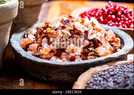 Raccolta di spezie indiane, sale di mare e roccia mescolato con peperoncino rosso caldo peperoni e altre spezie in ciotole di argilla da vicino Foto Stock