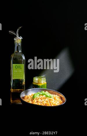 Pasta italiana, ceci fusilli con pesto all'aglio selvatico, olio d'oliva e foglie di basilico fresco Foto Stock