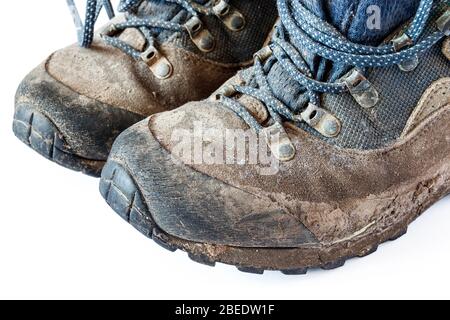 Un paio di stivali da trekking fangosi su sfondo bianco Foto Stock