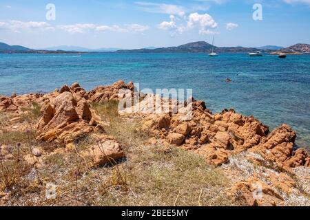 Tavolara, Sardegna / Italia - 2019/07/18: Pittoreschi porti del Mar Tirreno con yacht al largo dell'isola di Isola Tavolara al largo della costa settentrionale della Sardegna Foto Stock