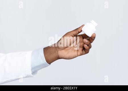 Scatola di tenuta per mano nera con pillole Foto Stock