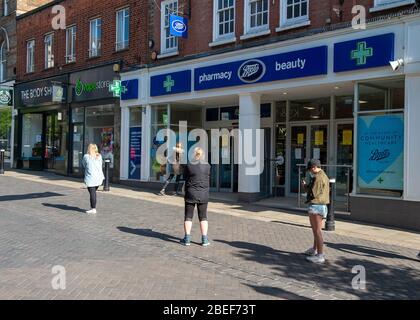 Windsor, Berkshire, Regno Unito. 13 aprile 2020. La gente aderisce alle linee guida governative sulle distanze sociali mentre attendono di entrare nella farmacia di Boots in Peascod Street, Windsor. Credit: Maureen McLean/Alamy Live News Foto Stock