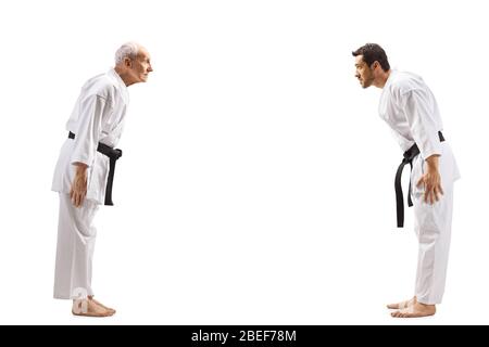 Foto di profilo a tutta lunghezza di giovane e anziano in kimonos kimonos karate inchinato su sfondo bianco Foto Stock