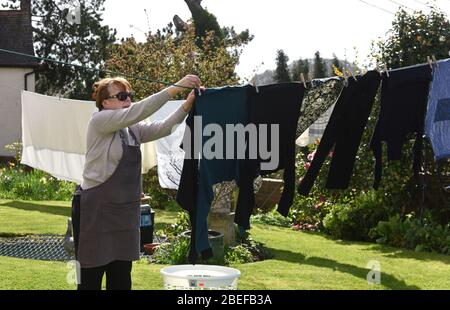 Donna appesa lavaggio sulla linea di vestiti Foto Stock